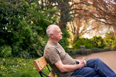 Photograph showing a man sitting on a park bench