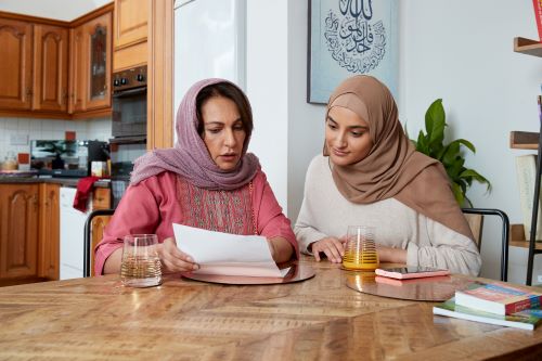 Two women sat at home looking at a letter