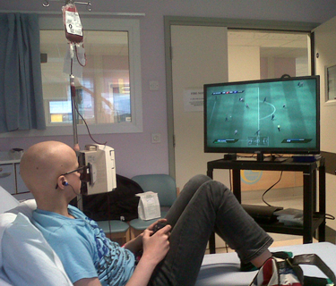 Young person with cancer playing a games console